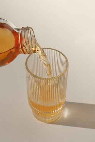 DELICIOUS GLASS OF KOMBUCHA BEING POURED INTO FANCY GLASS - BOOCHACHA