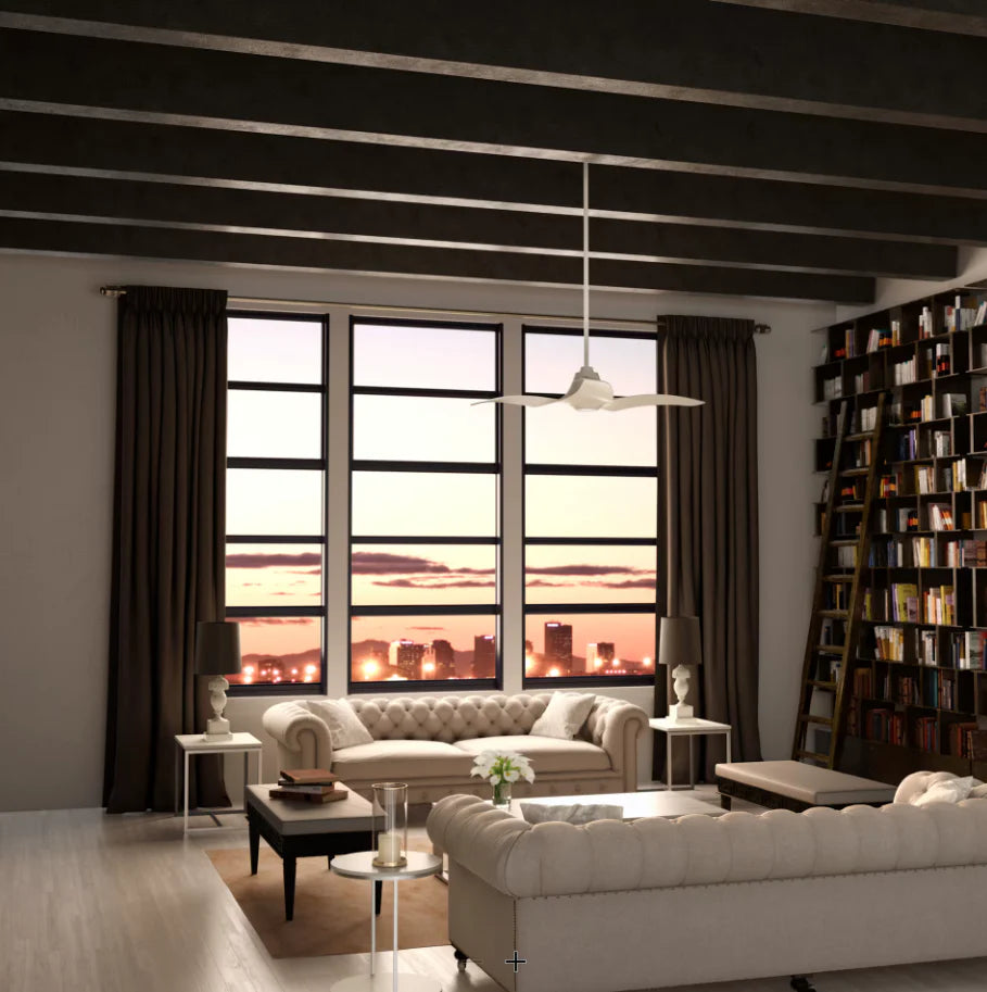 A living room with city views at sunset, tufted sofas, and a white ceiling fan hanging from a dark beamed ceiling.