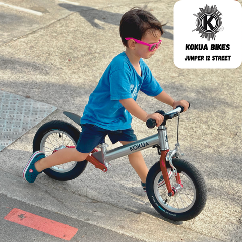 A young boy enjoying riding his KOKUA Bikes Jumper 12 Street Edition, Red