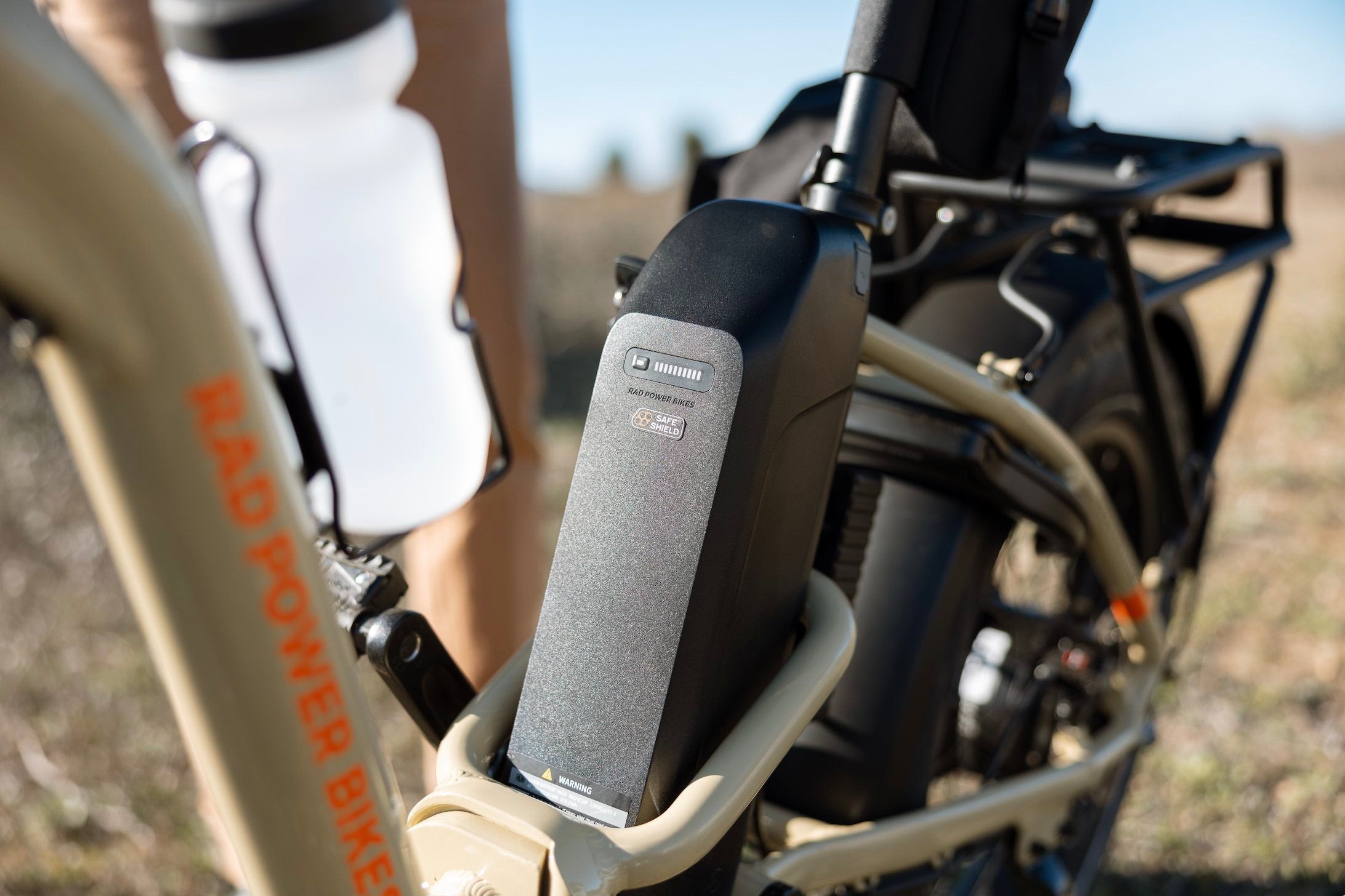 A close-up shot of a Safe Shield Battery on a RadExpand 5 Plus in a desert environment.