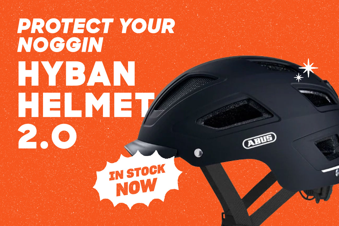 A Hyban helmet on an orange background. The text overlay says "Protect Your Noggin" and "In Stock Now"