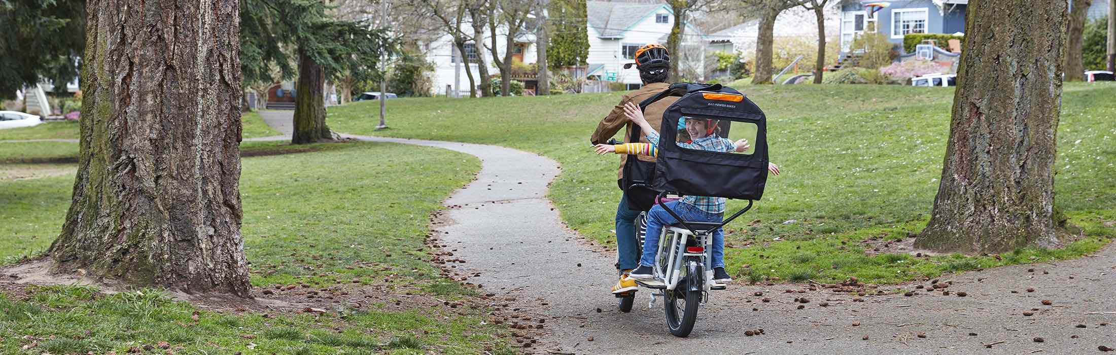 A father rides a RadWagon with his children in the Conestoga on a fall day.