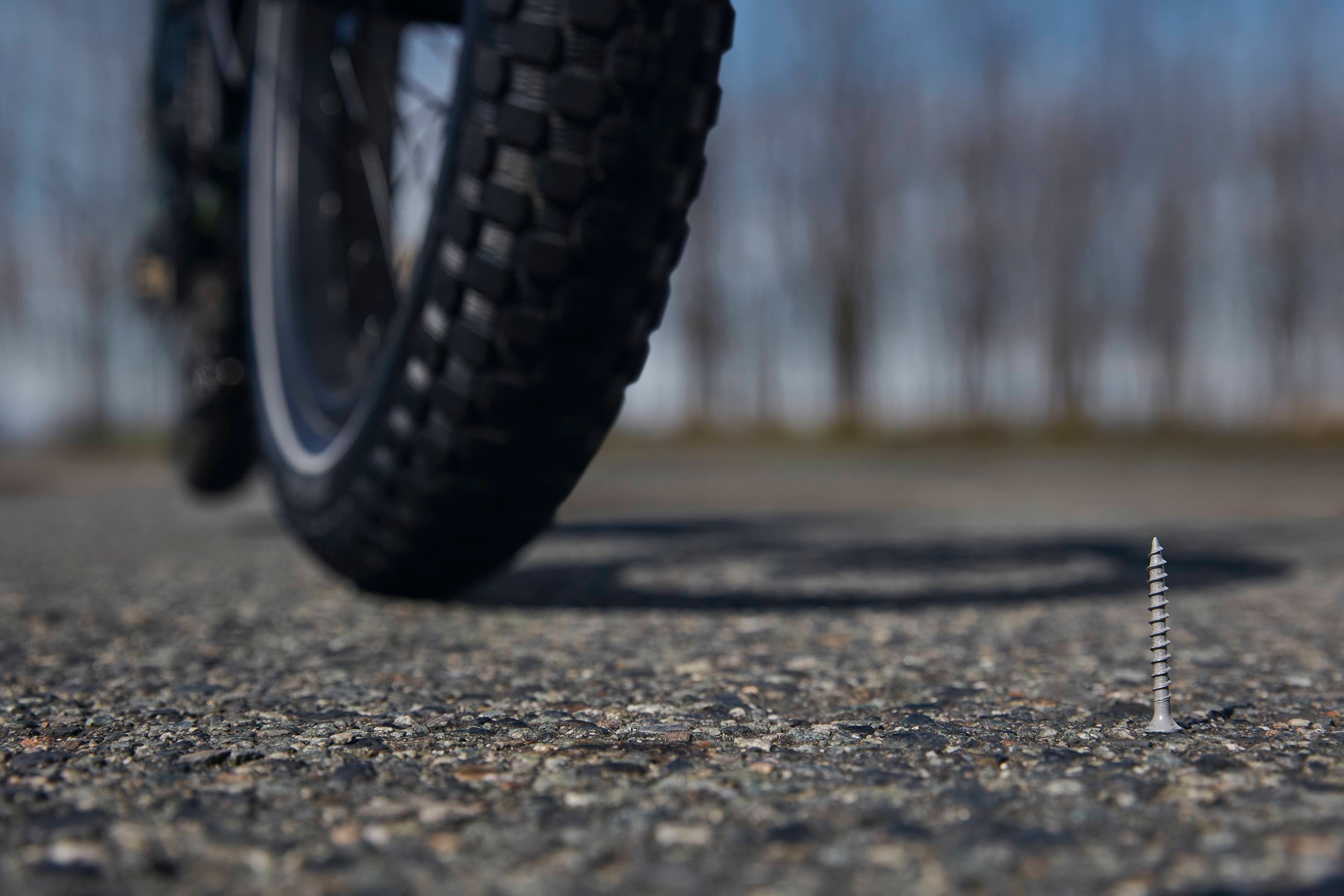 A close-up of an electric bike wheel approaching a menacing looking screw.