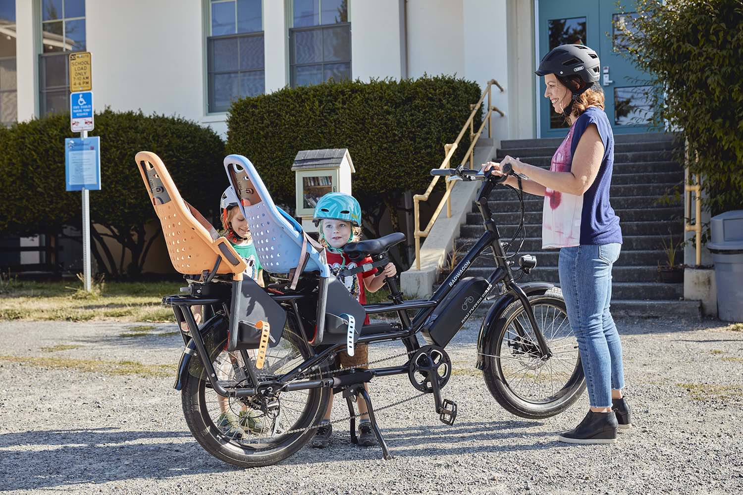 A mother picks up her two kids from school with the RadWagon 4 electric cargo bike.