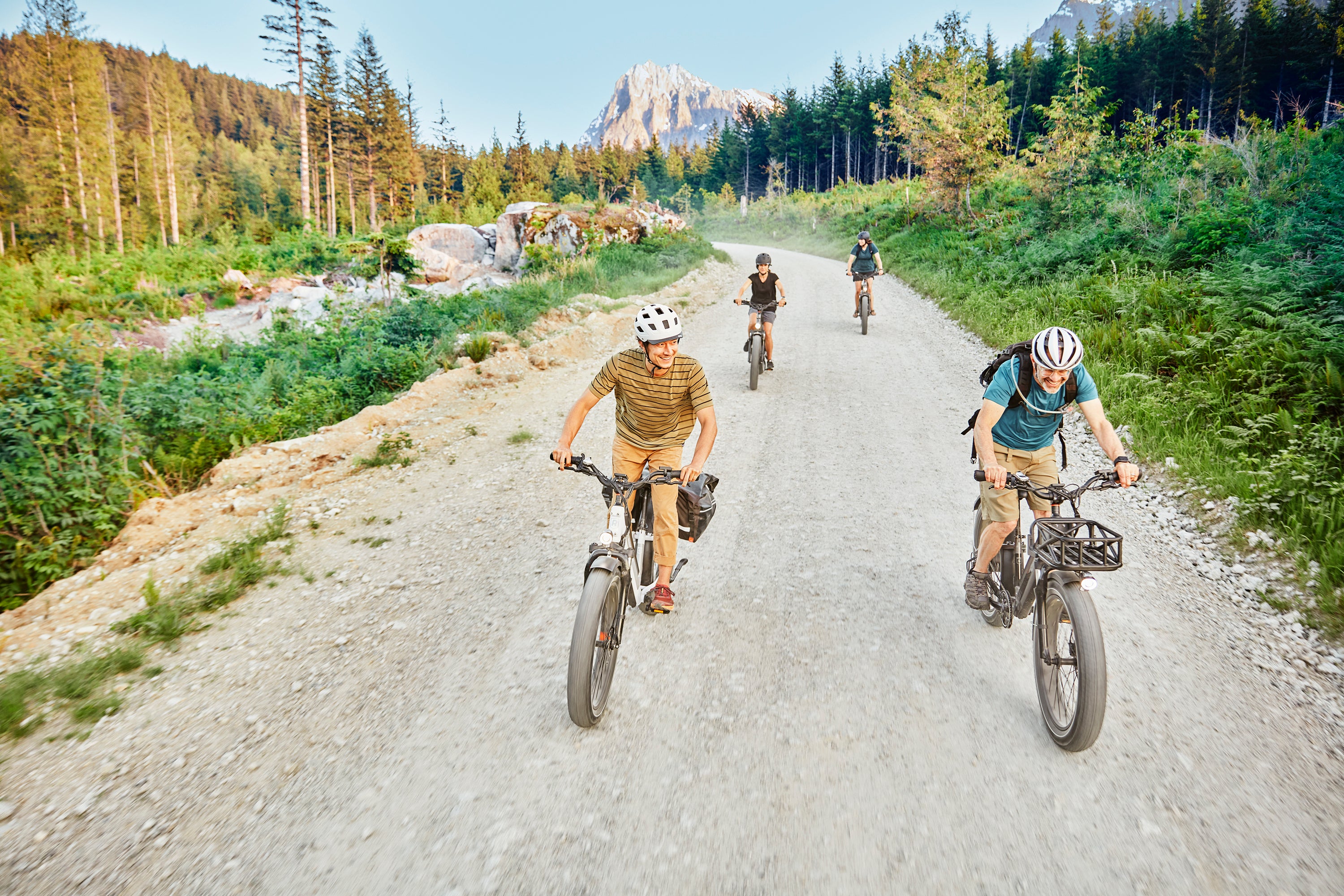 A family rides their RadRover 6 Plus up a mountain hill.