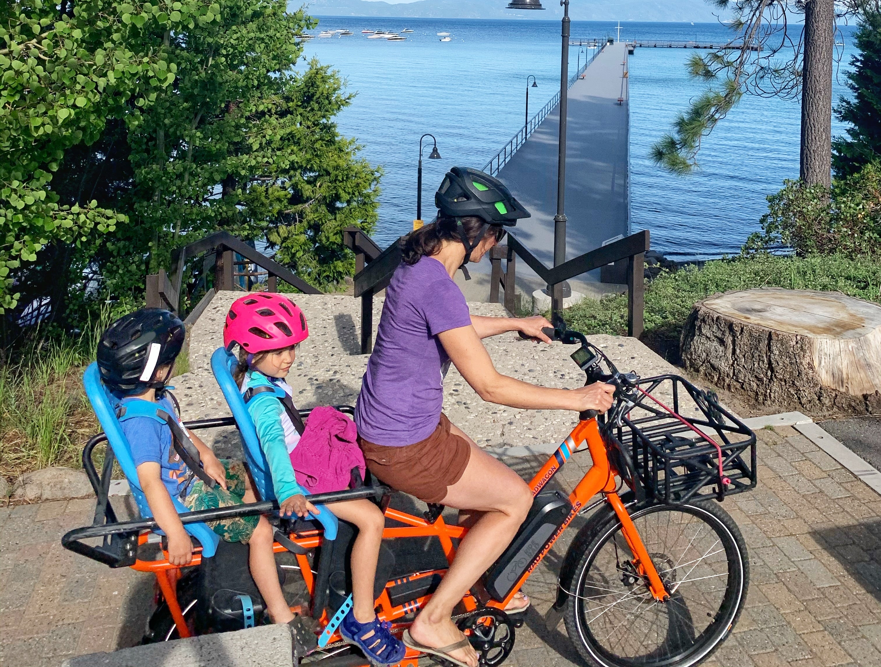 A woman rides her RadWagon with her kids along Lake Tahoe.