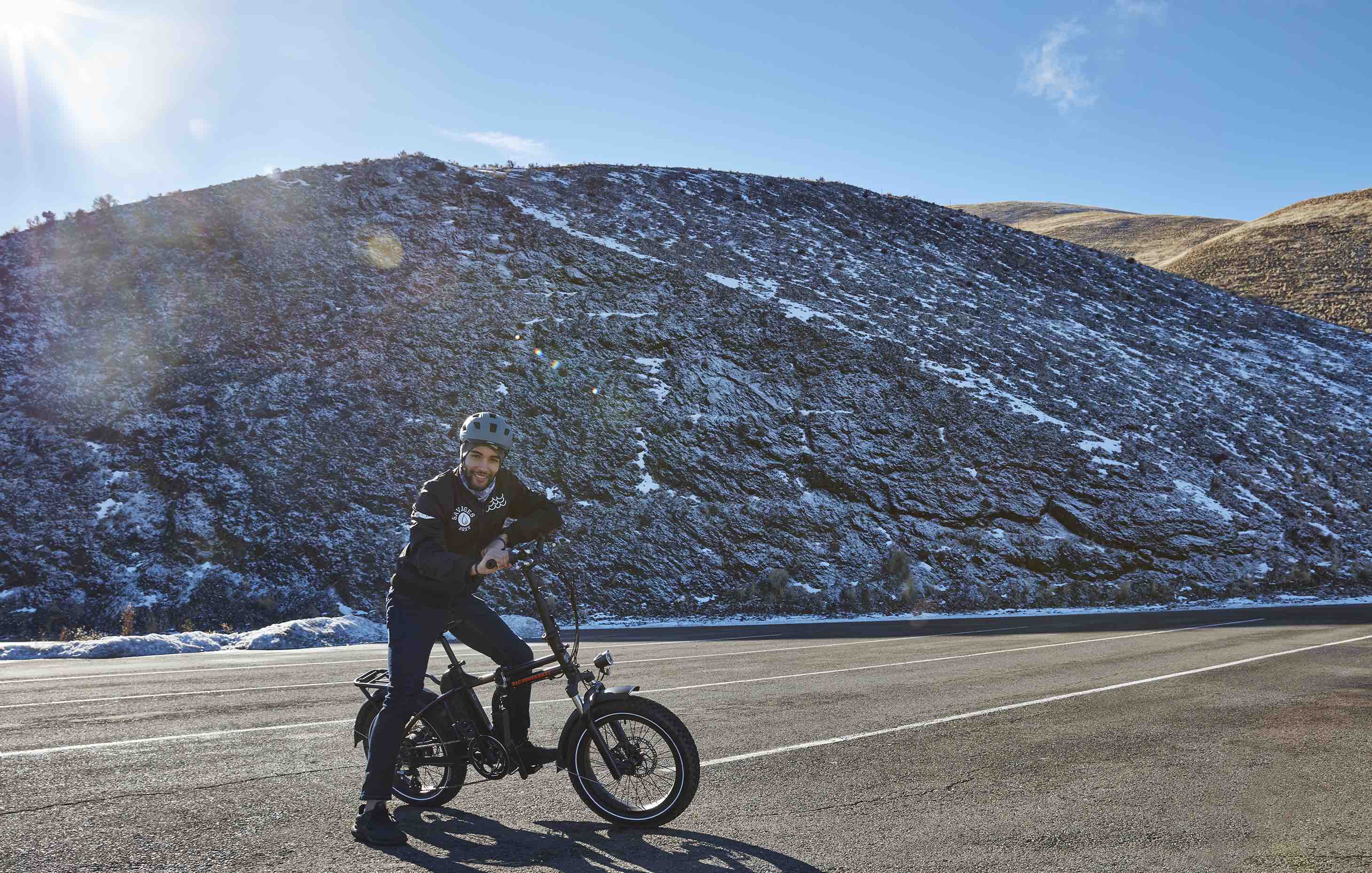 A young man poses with his RadMini on a rural mountain road.