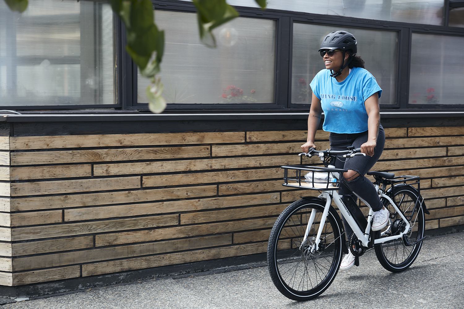 A young woman proudly walks alongside her RadMission electric metro bike.