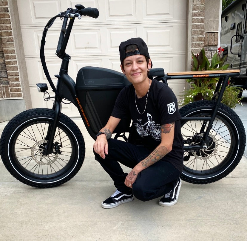 Individual poses with a grin in front of their black RadRunner ebike.