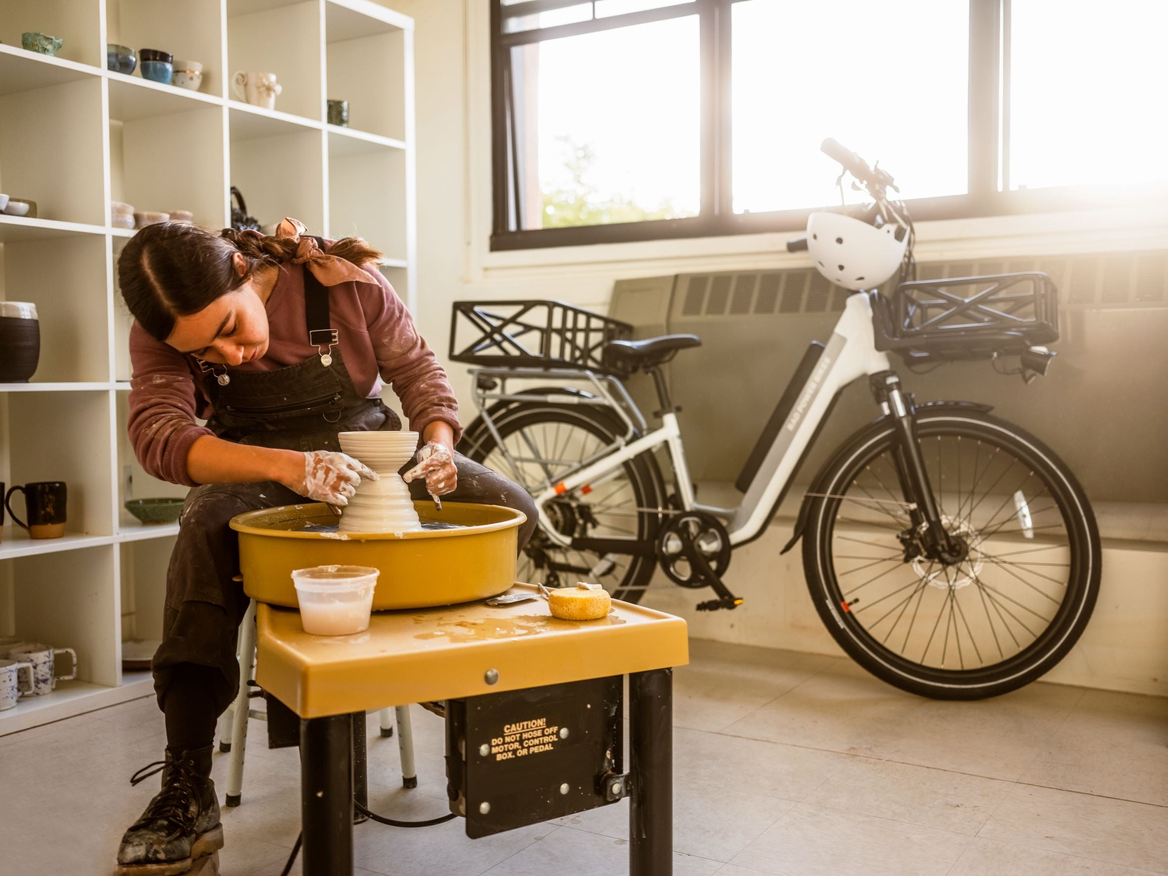 A sculptor crafts pottery on a pottery wheel.