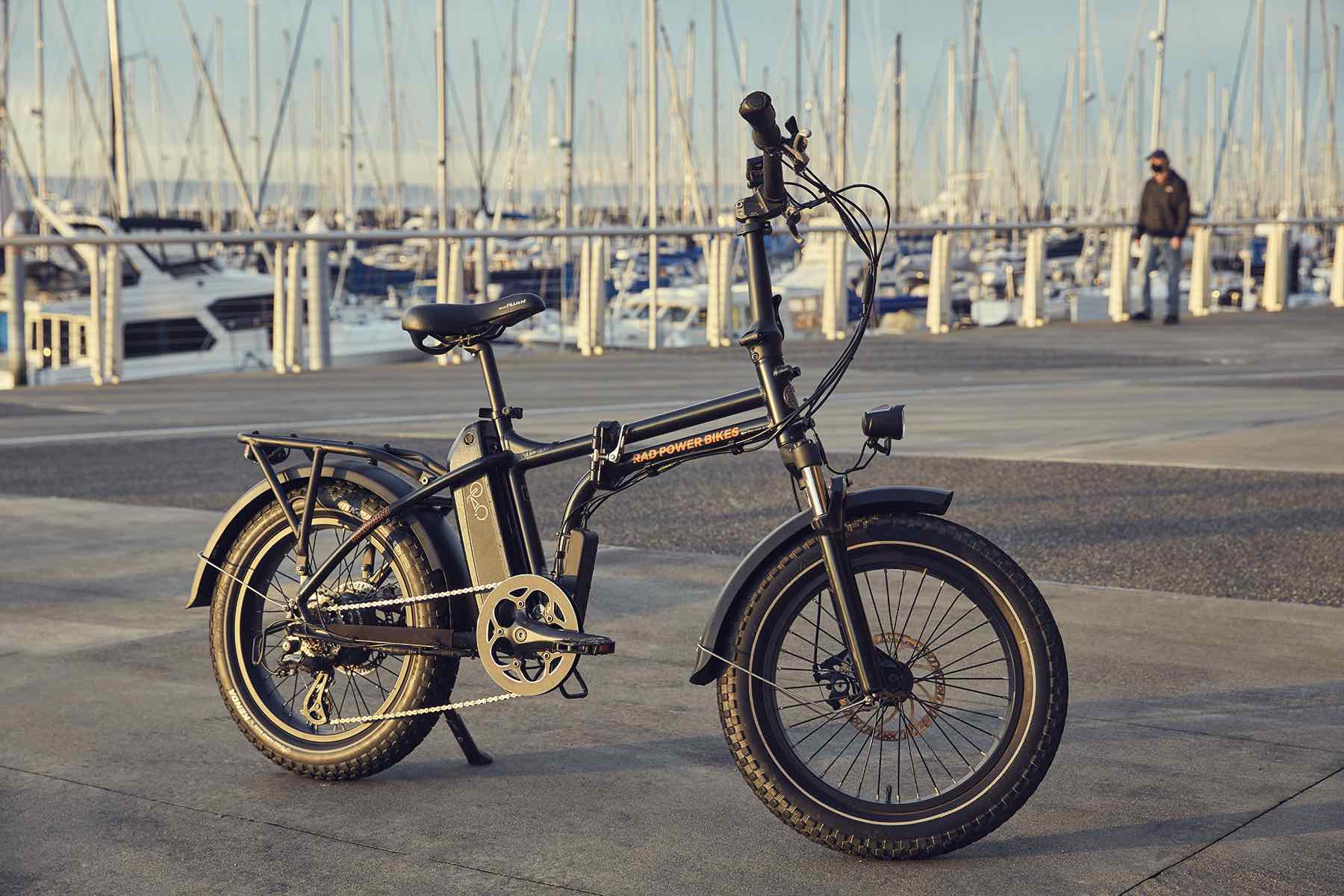 A RadMini parked on a seaside dock alongside several sailboats.