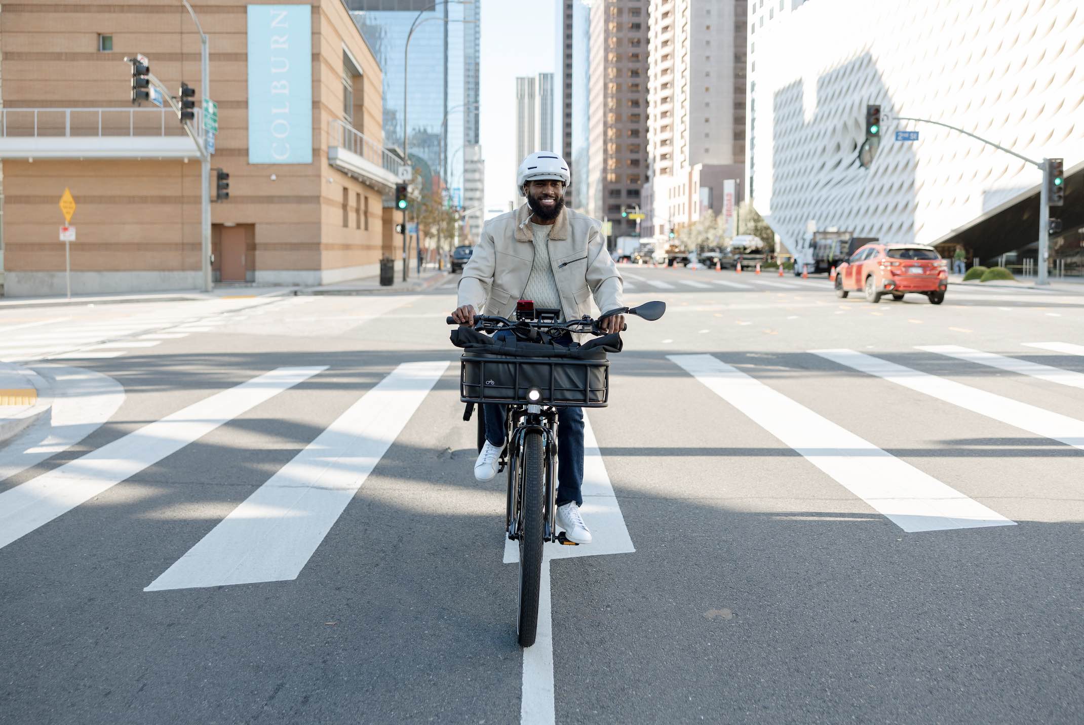 A head-on shot of a man riding a Radster Road through a city street.