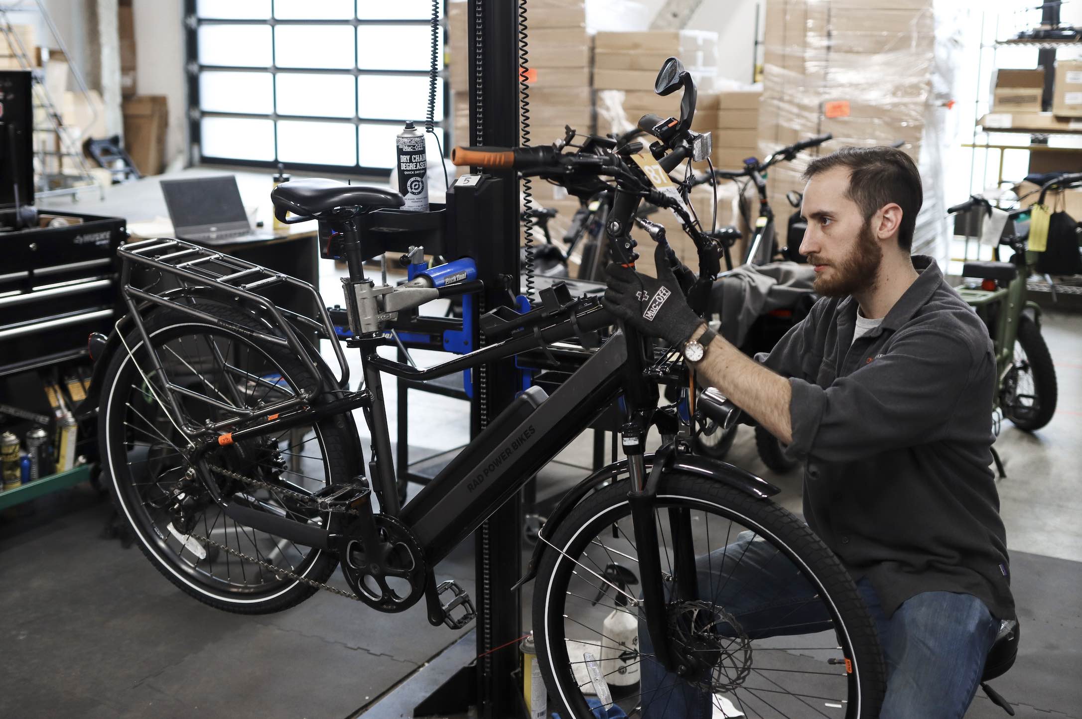 A mechanic works on a black Rad Power Bikes ebike.