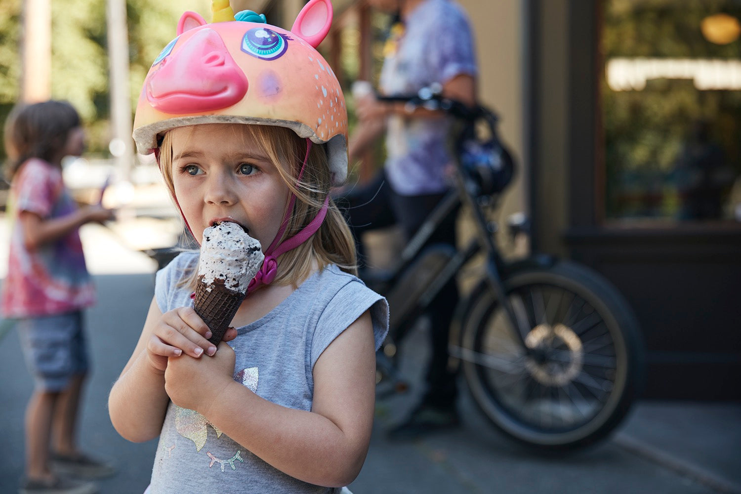 A young girl eats ice cream alongside a RadWagon.