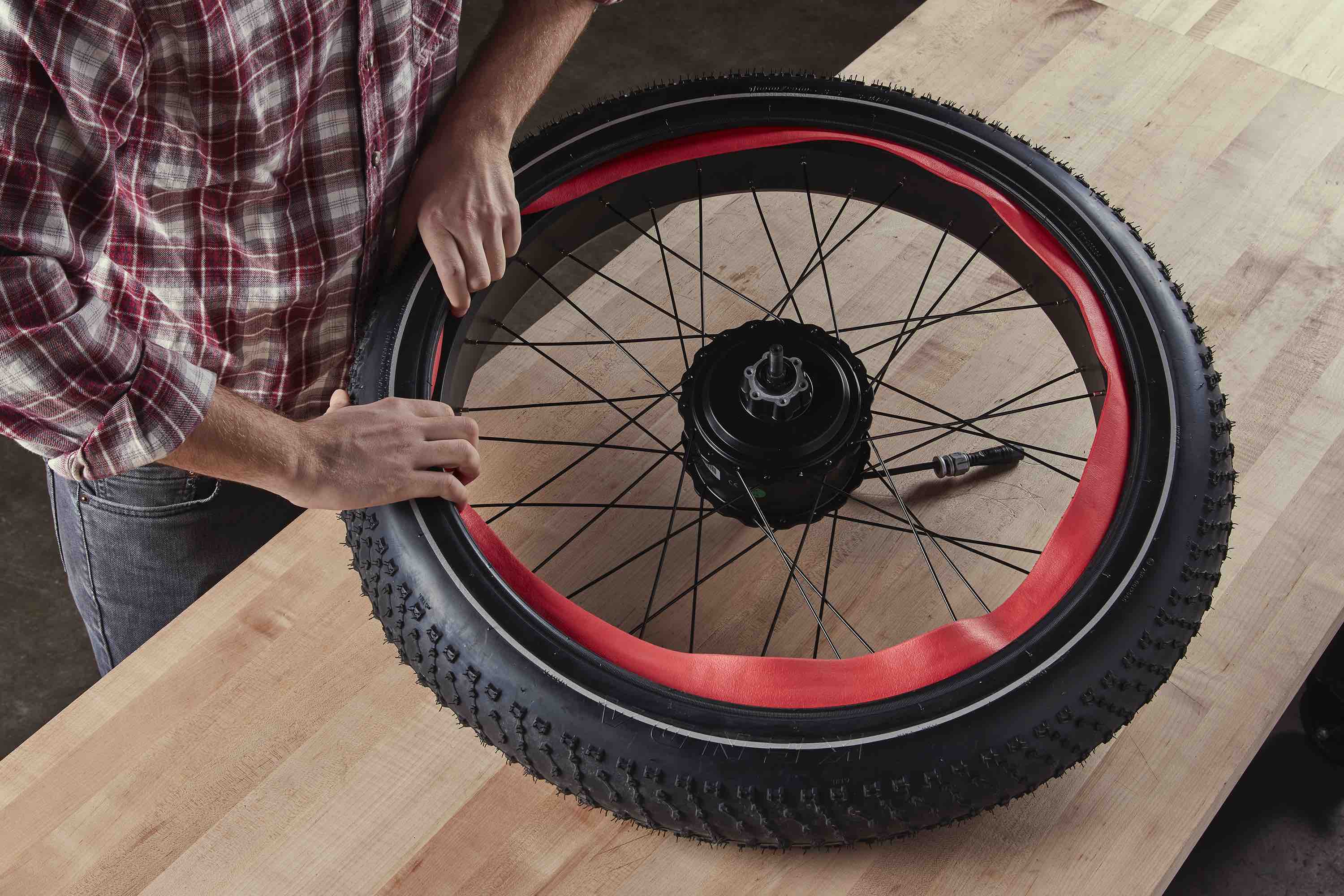 A man installs Tannus Tire Armour on his electric bike tire