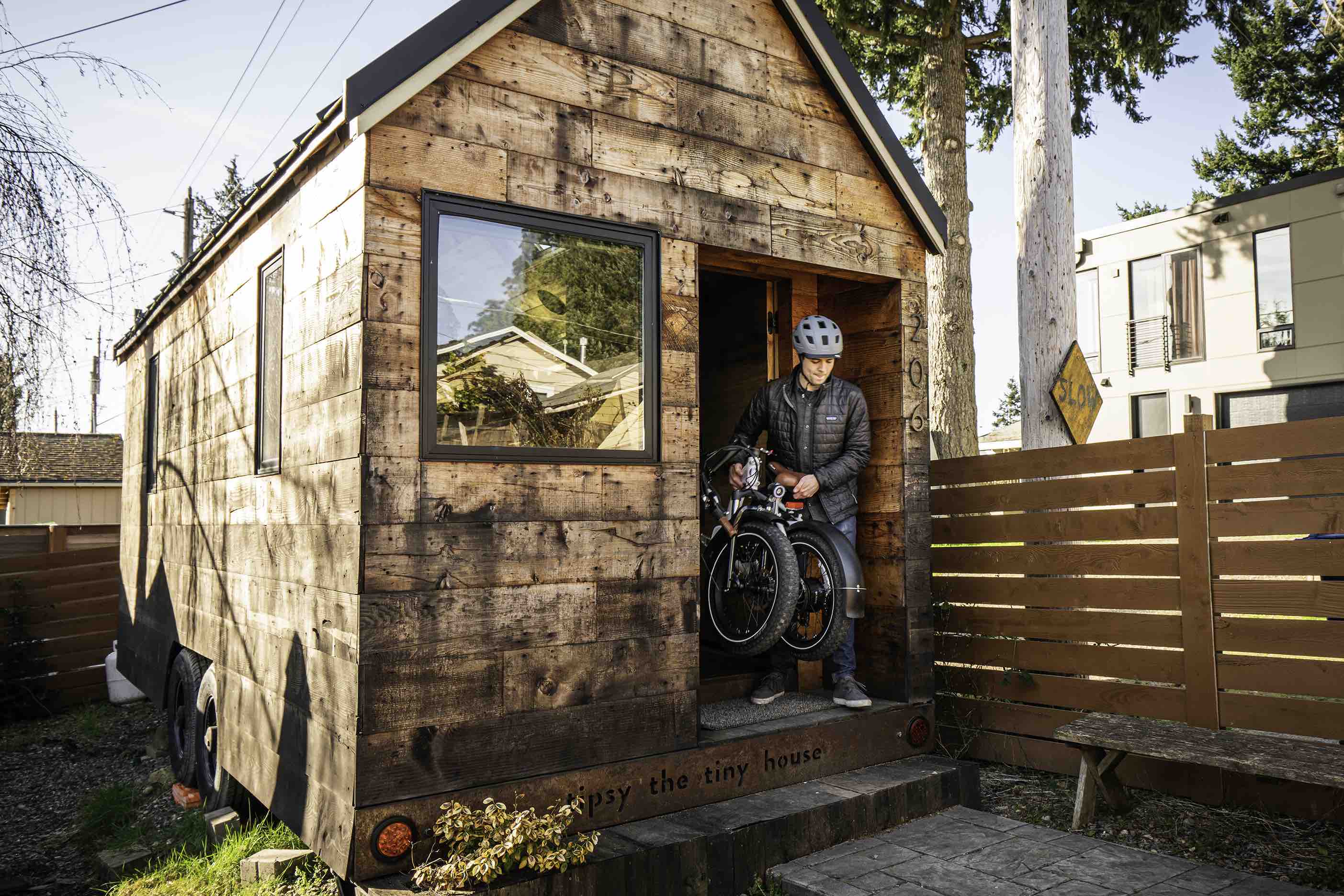 A man exits a tiny house with his RadMini electric folding bike.