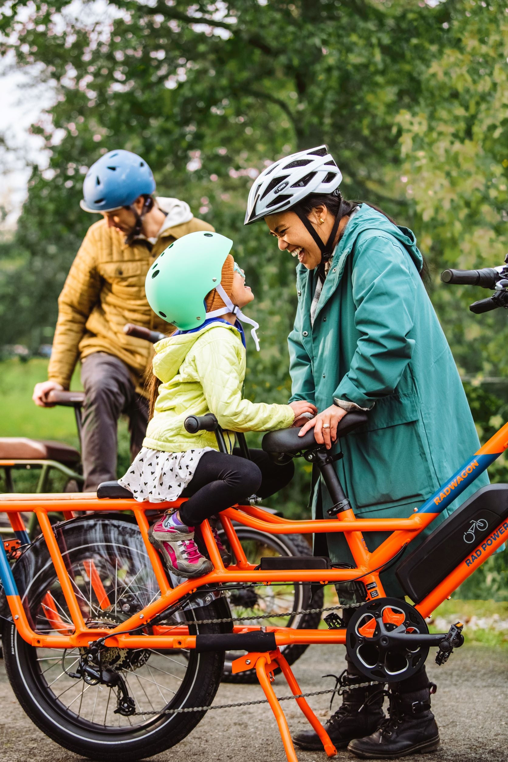 Mom, dad, and daughter get ready to ride their RadWagon cargo electric bikes.