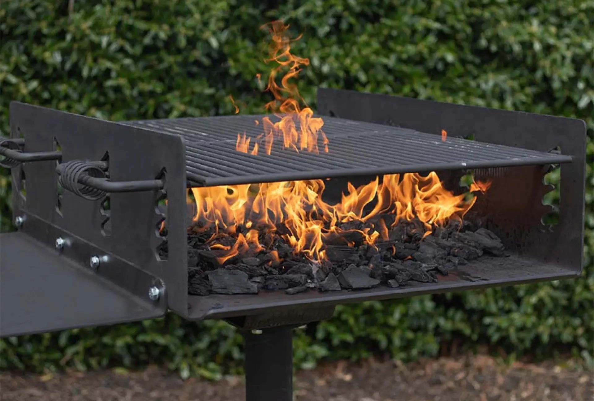 Outdoor built-in charcoal grill with flames and charcoal