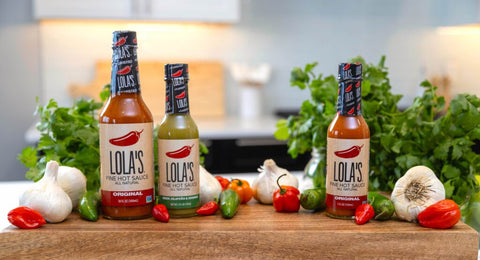 lola's original and green jalapeno hot sauces on kitchen counter