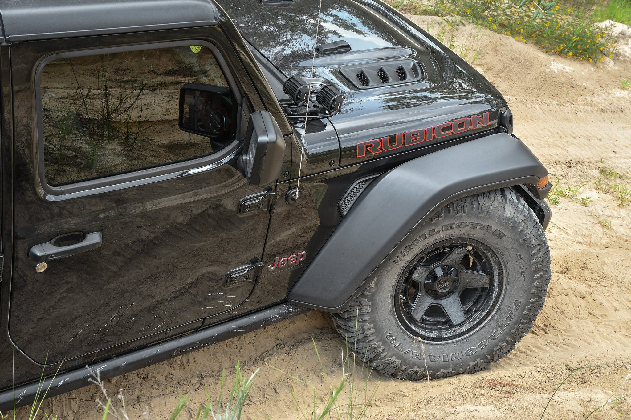 overland sector wheels jeep gladiator rubicon on 17x9 satin black atlas wheels in woods dirt trail up close of wheel