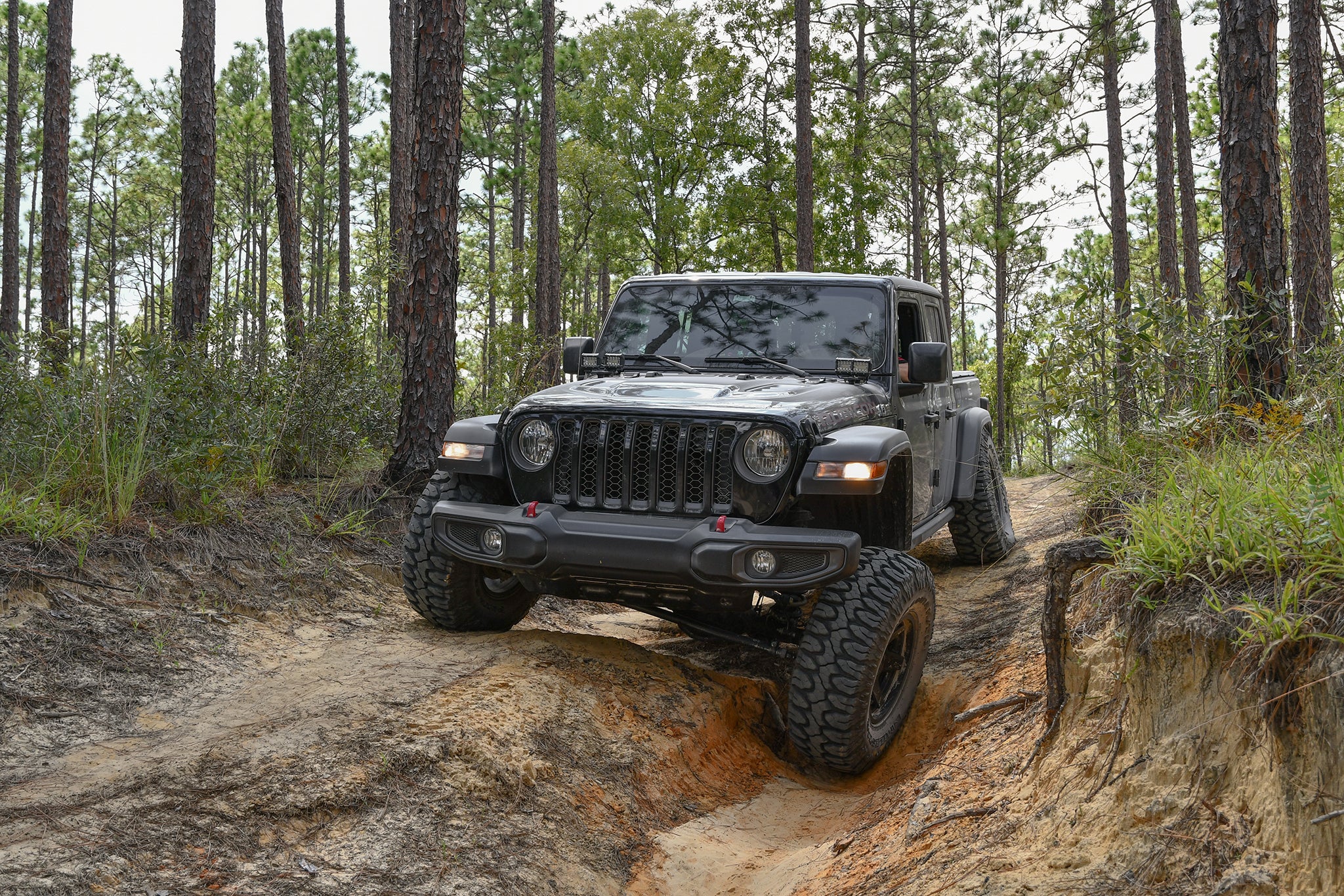 overland sector wheels jeep gladiator rubicon on 17x9 satin black atlas wheels in woods dirt trail
