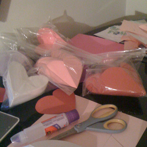 stacks of paper heart shapes in white, pink, and red for valentine's card making