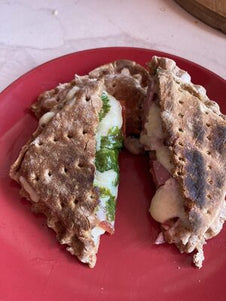A toasted snack filled with spinach, cheese and ham