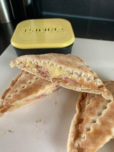 A toasted snack with cheese and ham filling next to the CRIMPiT square