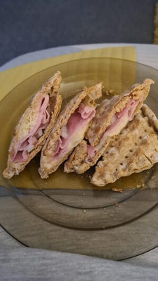 A toasted snack filled with ham, cheese and onion