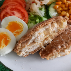 A toasted snack filled with cheese and egg served with salad and baked beans