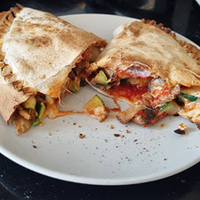 A wrap filled with mixed vegetables and a tomato sauce 