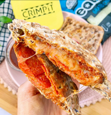 A toasted snack with tomato, meat and cheese filling next to the CRIMPiT square