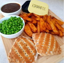 Two toasted snacks served with chips and peas