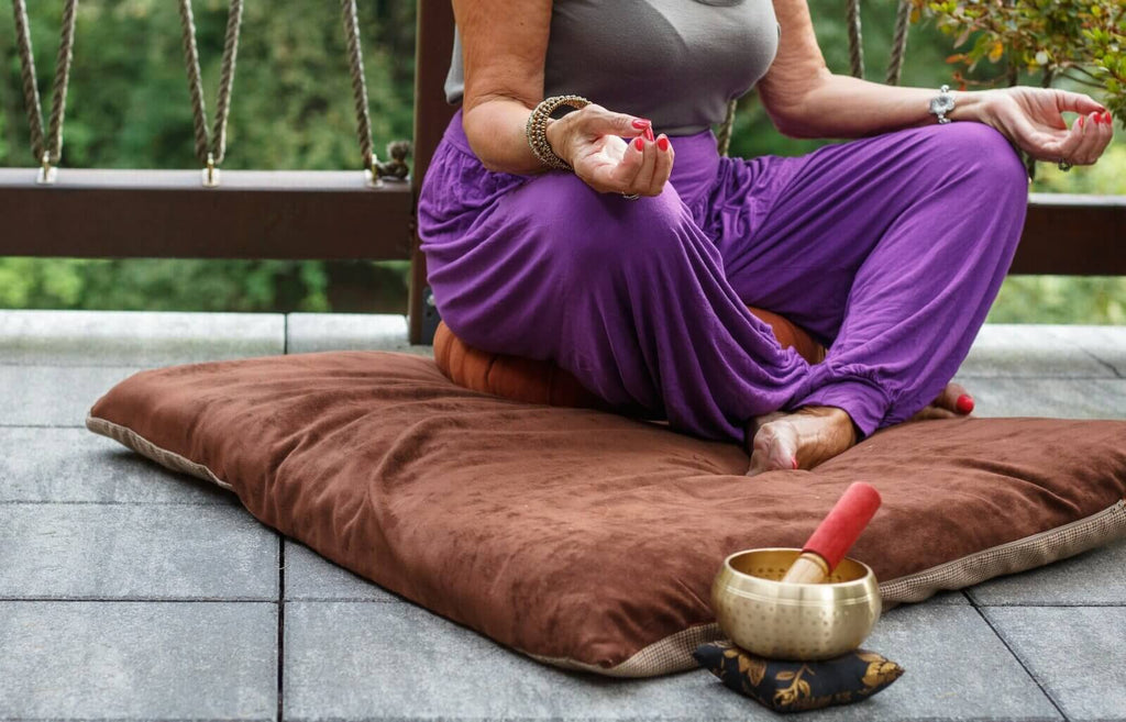 Woman meditates with singing bowl