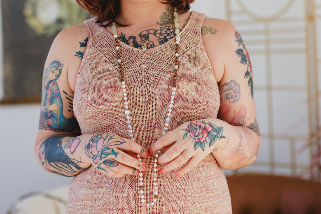 A close up shot of a beautiful rose gold silk hand knit tank top. The pattern features a tunic and a tank length.