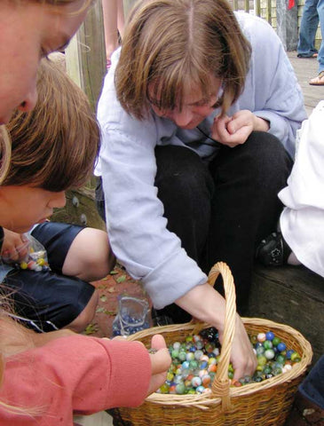 Loren and children pick out marbles from a basket