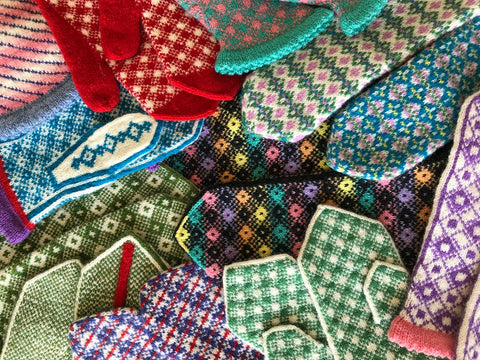 A colorful pile of many Fair Isle mittens