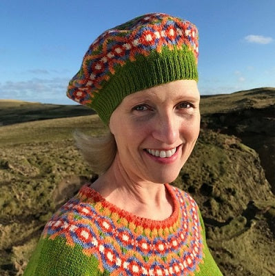 Jennifer Daley wearing a green Fair Isle hat and matching yoke sweater, which she designed on Fair Isle, Shetland, Scotland.