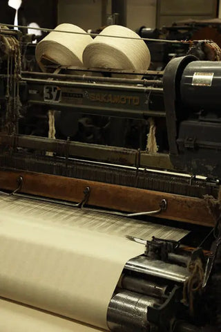 An old shuttle loom weaving a fabric.
