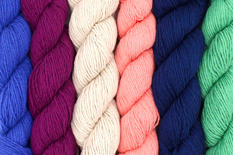 Brightly colored Skeins of Yarn Recycled from Unwanted Textiles ranging from Navy Blue to Ivory