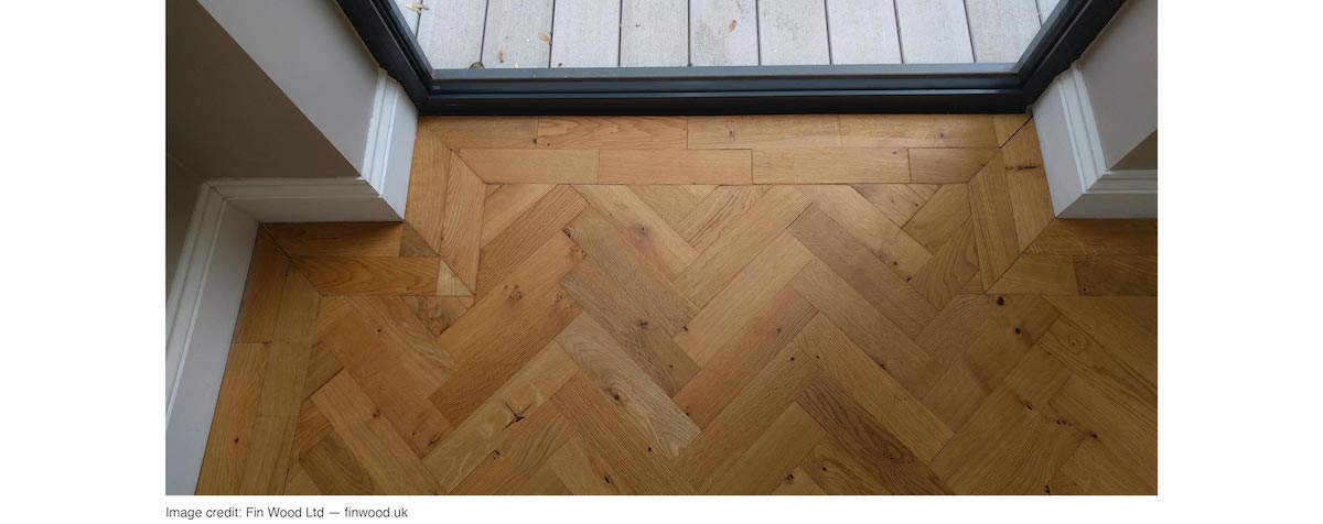Natural wood herringbone floor installed with a double border of the same wood
