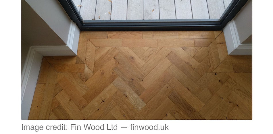 Natural wood herringbone floor installed with a double border of the same wood