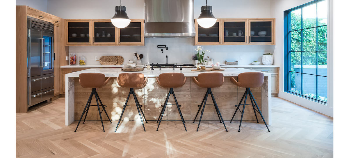 Grand open style kitchen with herringbone style wood flooring