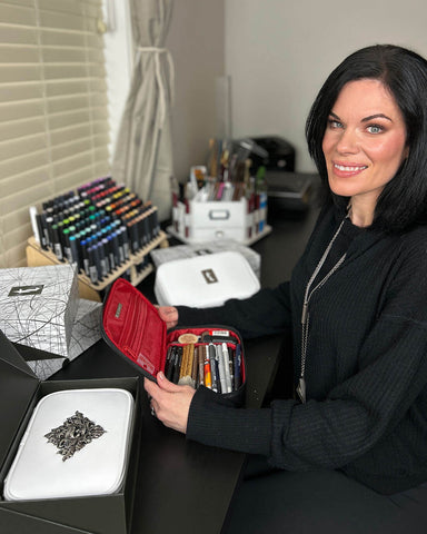 Dawn McTeigue, creator of Tempermentals, seated at her desk surrounded the pencil cases from her brand.