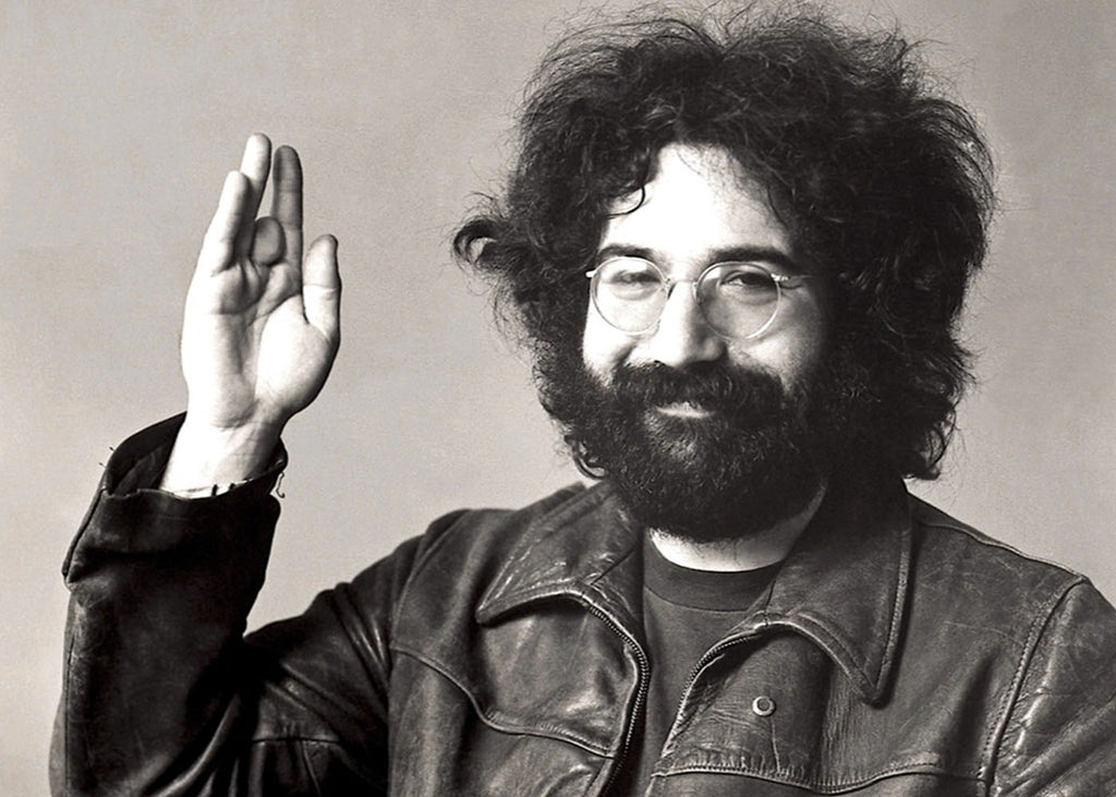 Jerry Garcia holding up his right hand with missing middle finger. 