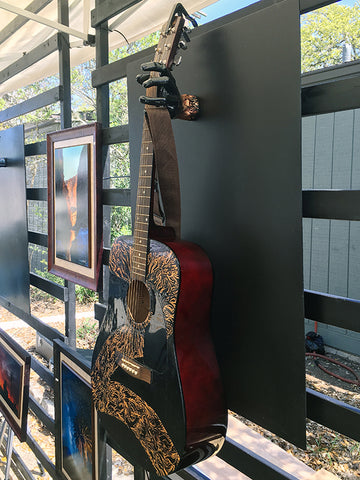 Acoustic guitar hand painted and mounted to display wall.