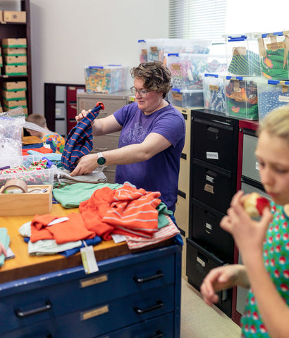 Behind the scenes - Kirsten pulling out sample clothes in the Hoopla Kids Stockroom