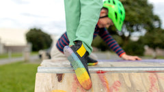 Image shoes two young people on top of a skate ramp, wearing bright coloured PaperKrane shoes