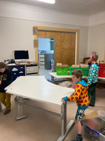 The Hoopla Kids setting up desks in the new stockroom space