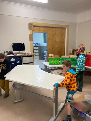 The notjustvisualphotobooths setting up desks in the new stockroom space